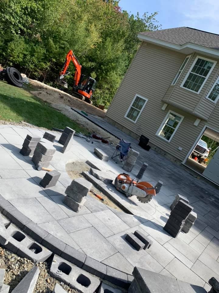 A patio is being built in front of a house.