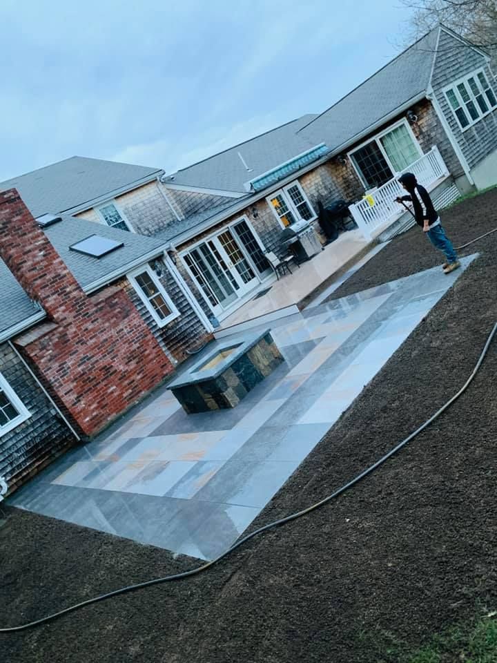A man is standing on a patio in front of a house.