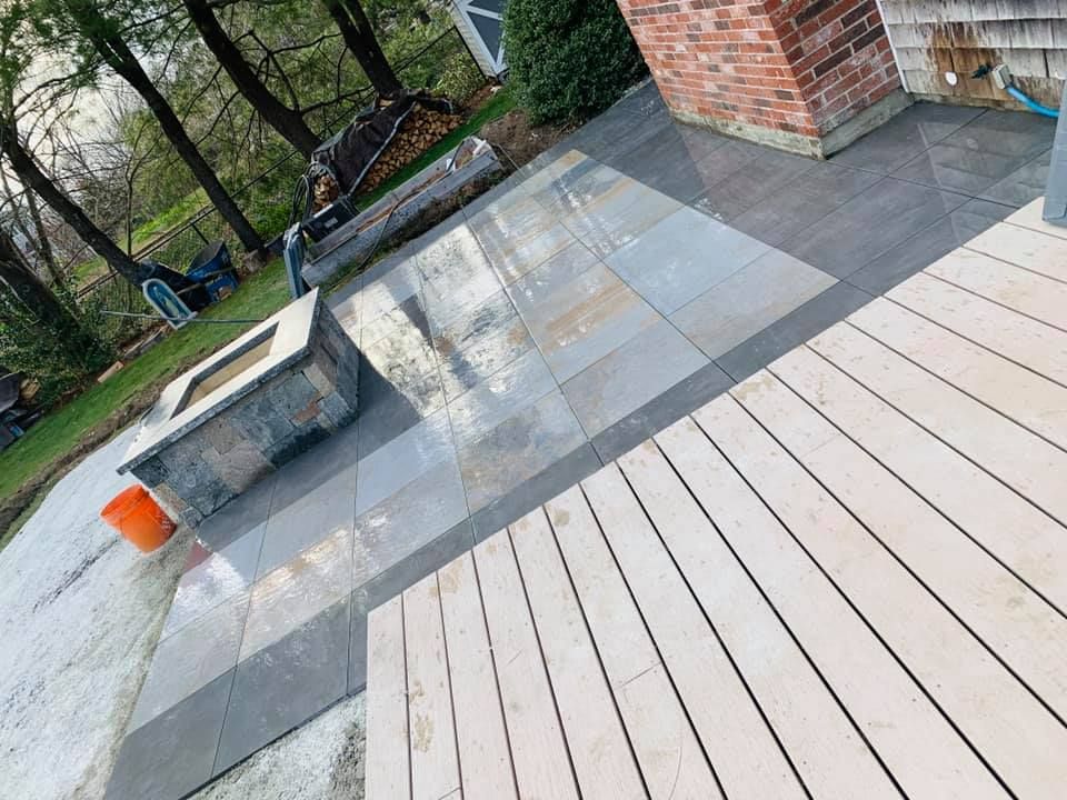 A wooden deck with a fire pit in the middle of it.