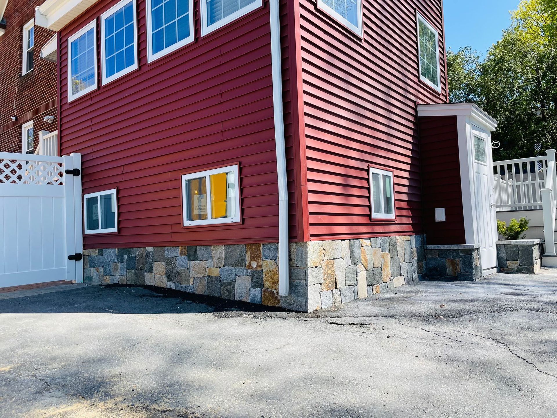 A red house with a white garage door and a driveway