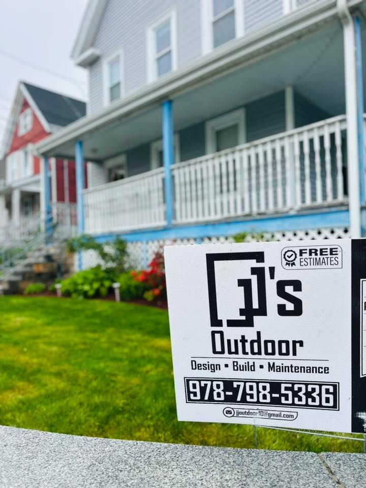 A sign for JJ's outdoor is in front of a house