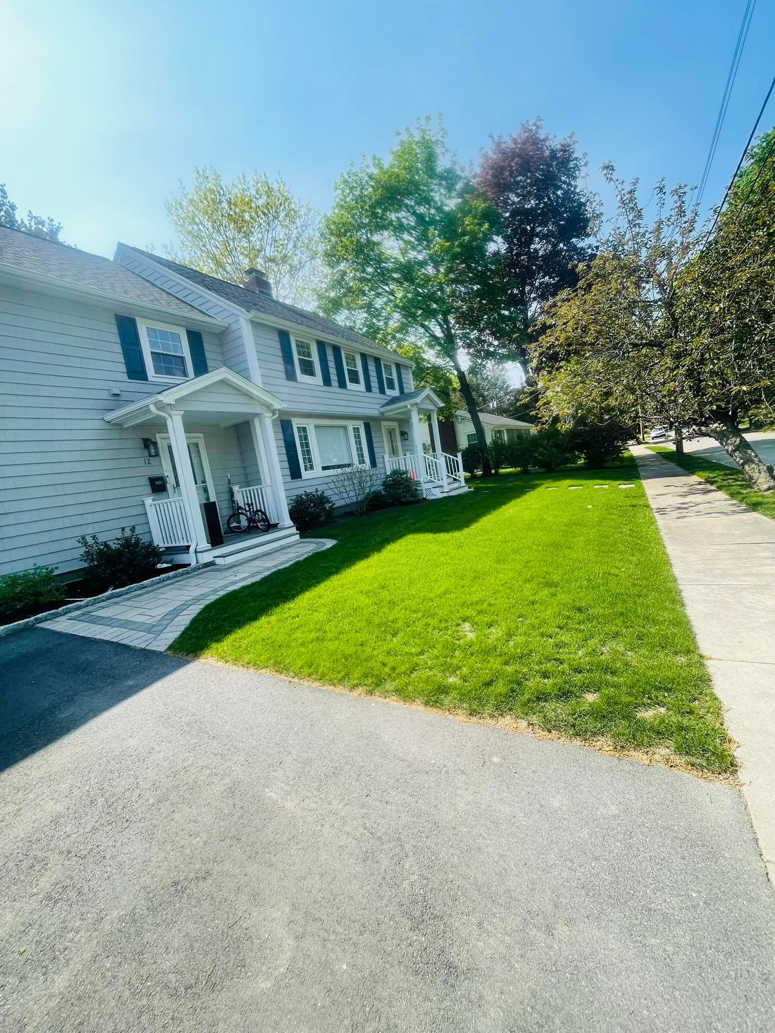 A white house with a large lawn in front of it.
