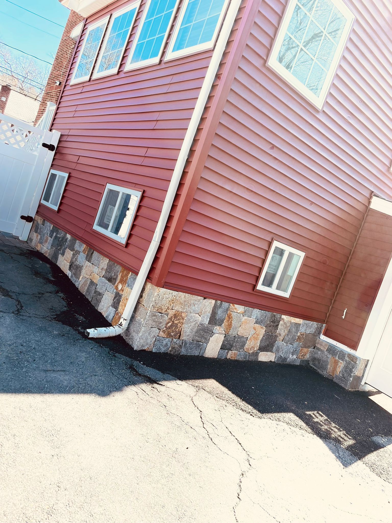 A red house with a lot of windows is sitting on top of a pile of dirt.
