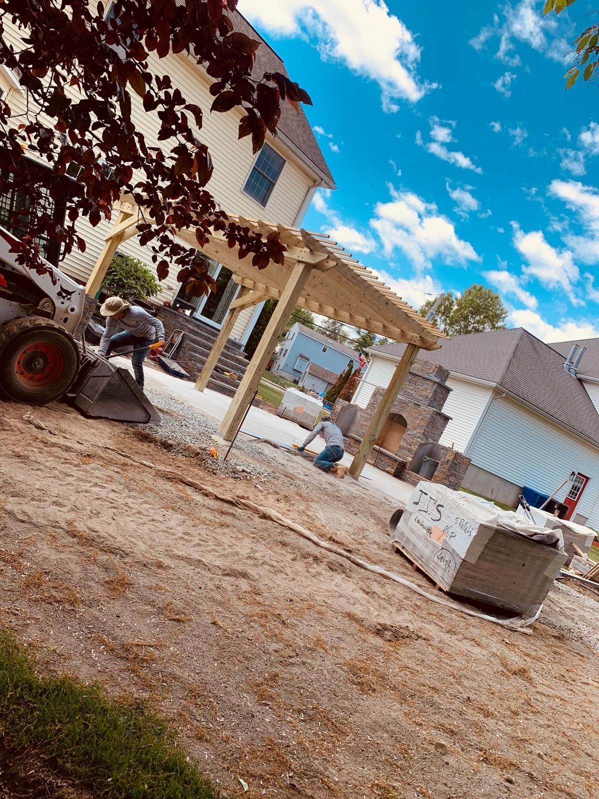 A group of people are working on a patio in front of a house.