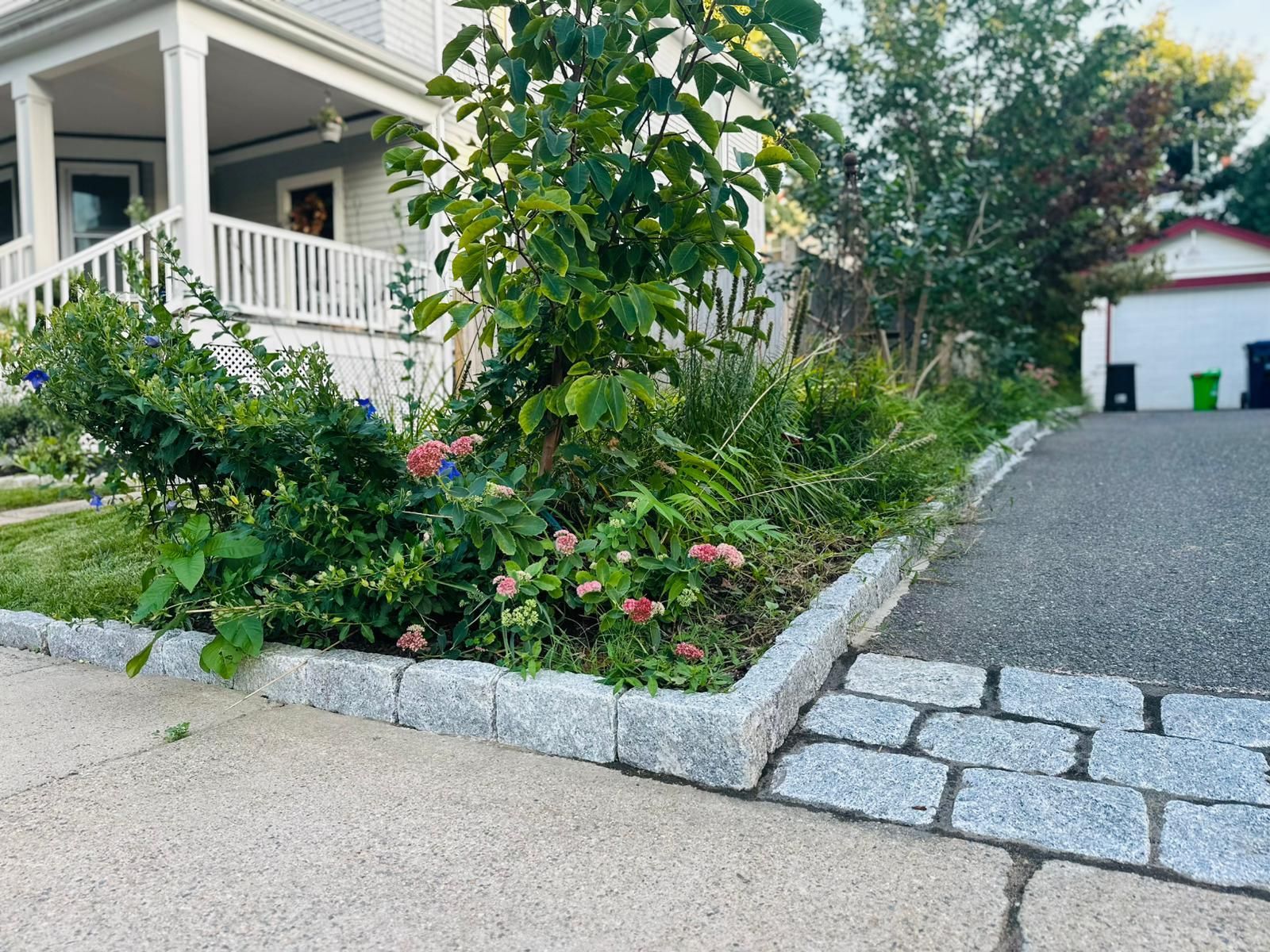A house with a driveway and a garden in front of it