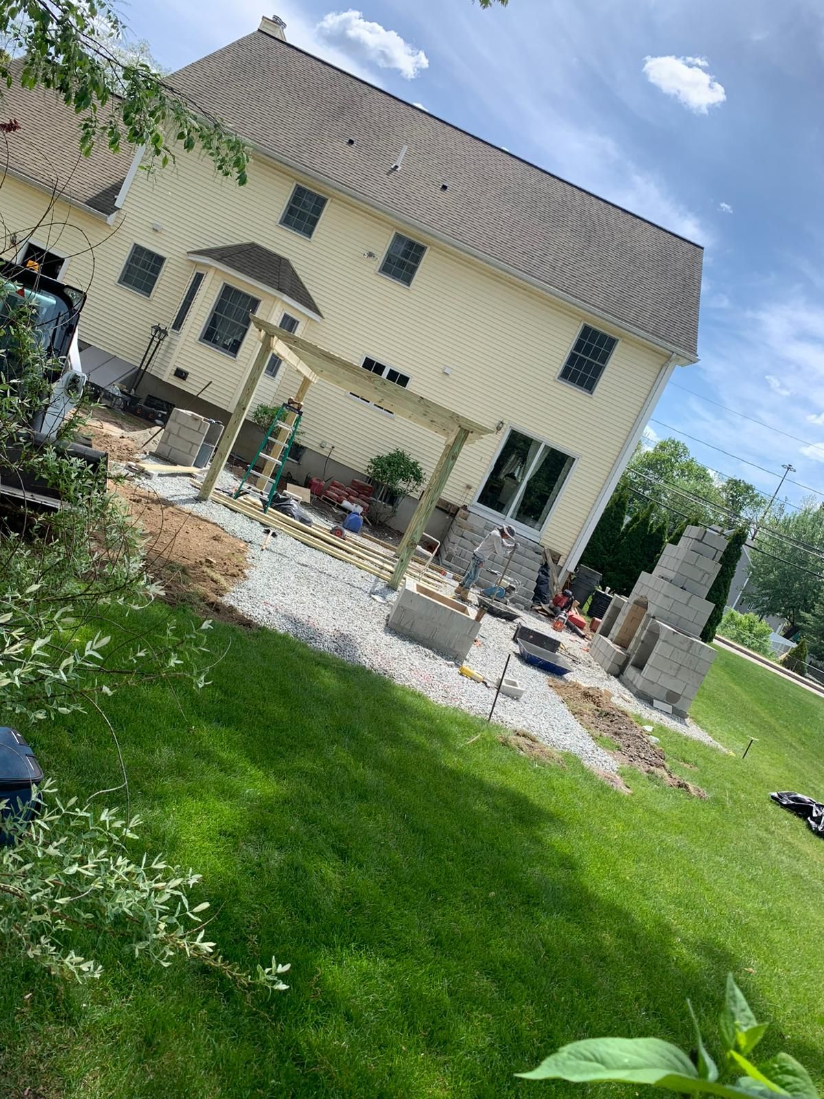 A large white house is sitting on top of a lush green field.