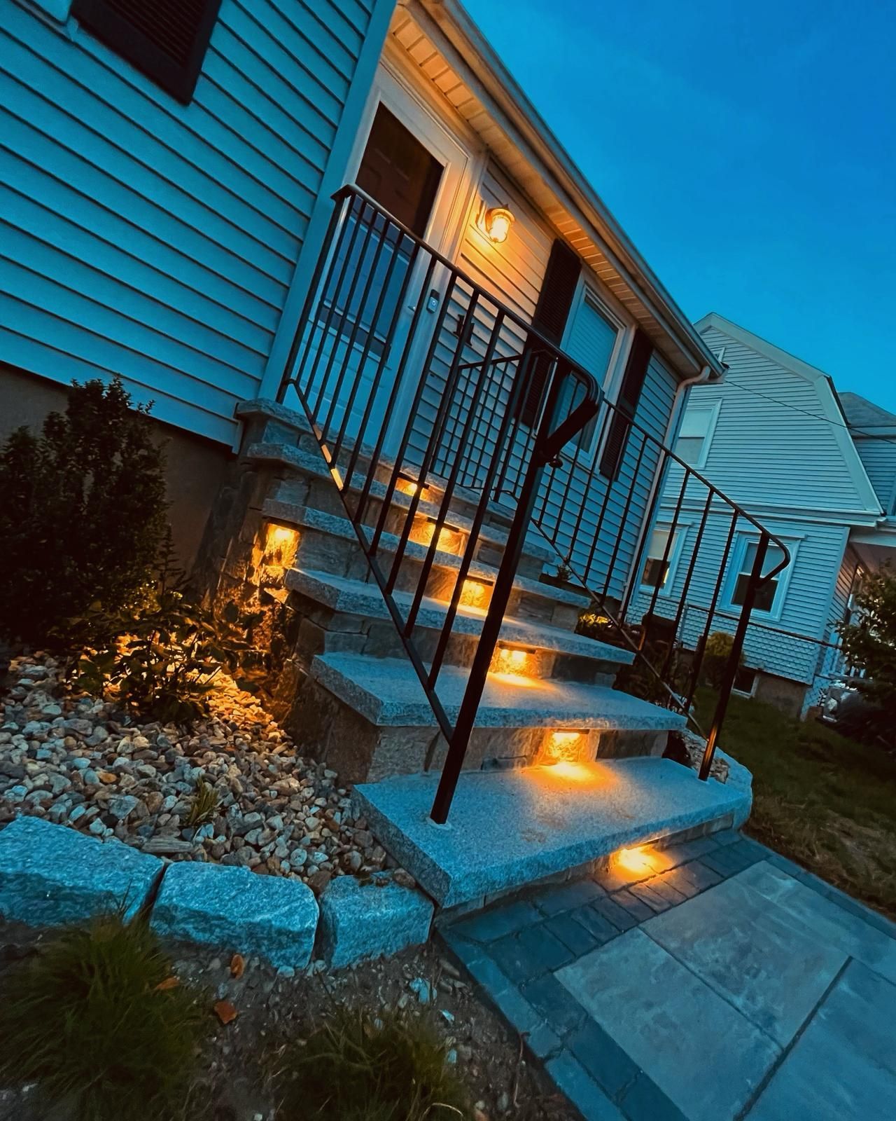 A house with stairs that are lit up at night.