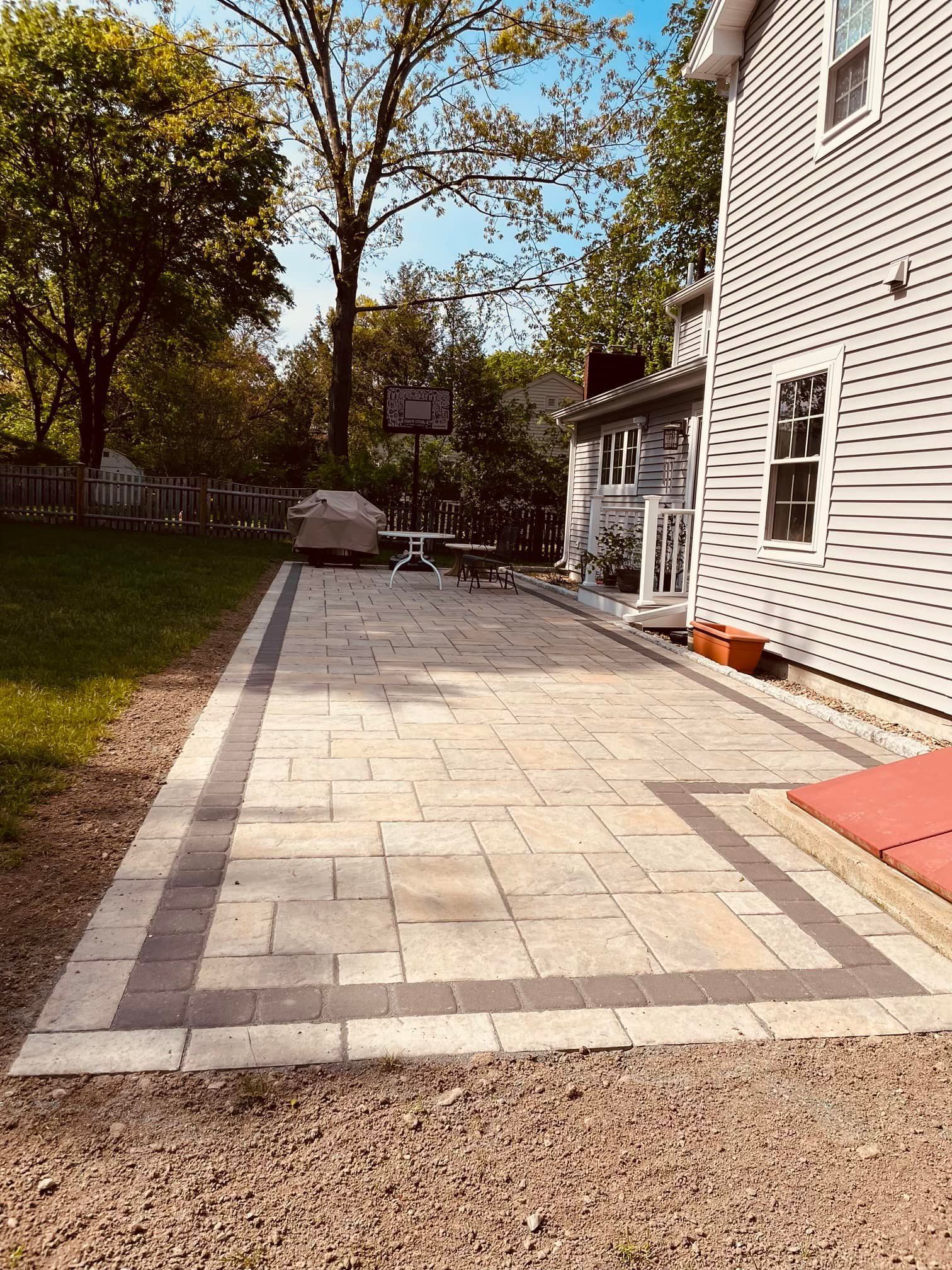 There is a patio in the backyard of a house.
