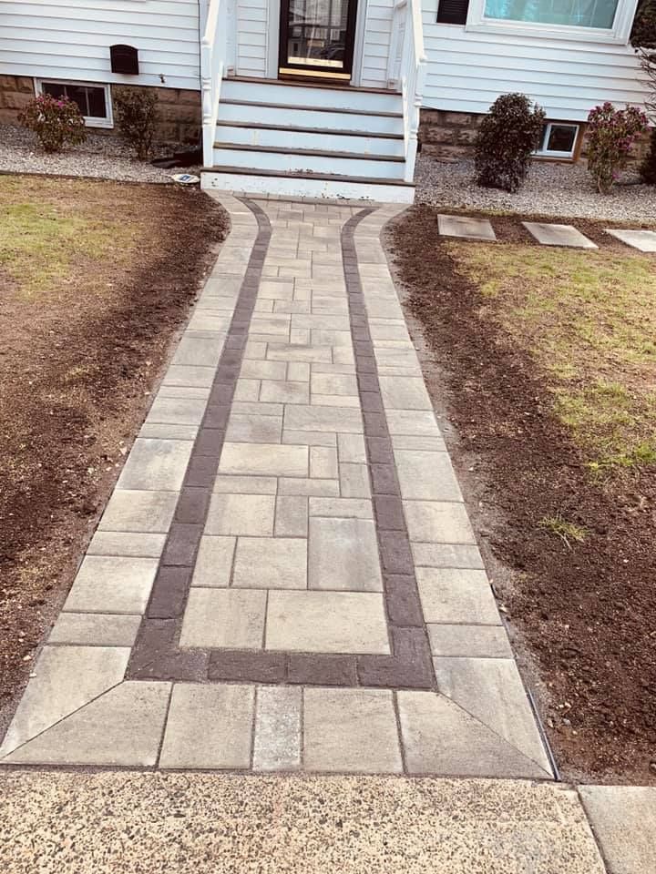 A brick walkway leading to the front door of a house.