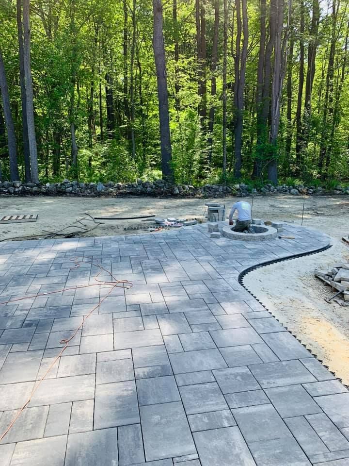 A patio is being built in the middle of a forest.
