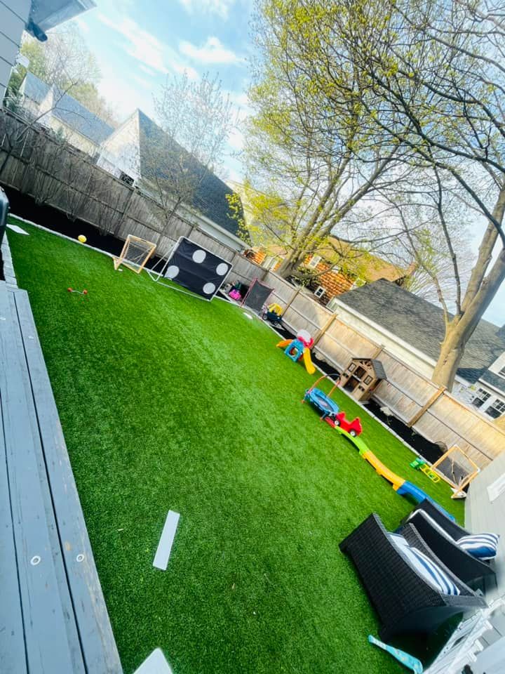 A backyard with a lot of grass and toys.