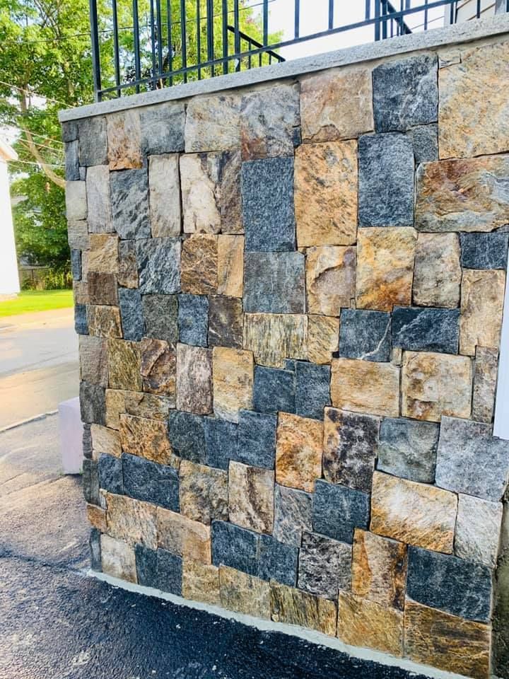 A stone wall with a staircase in the background.