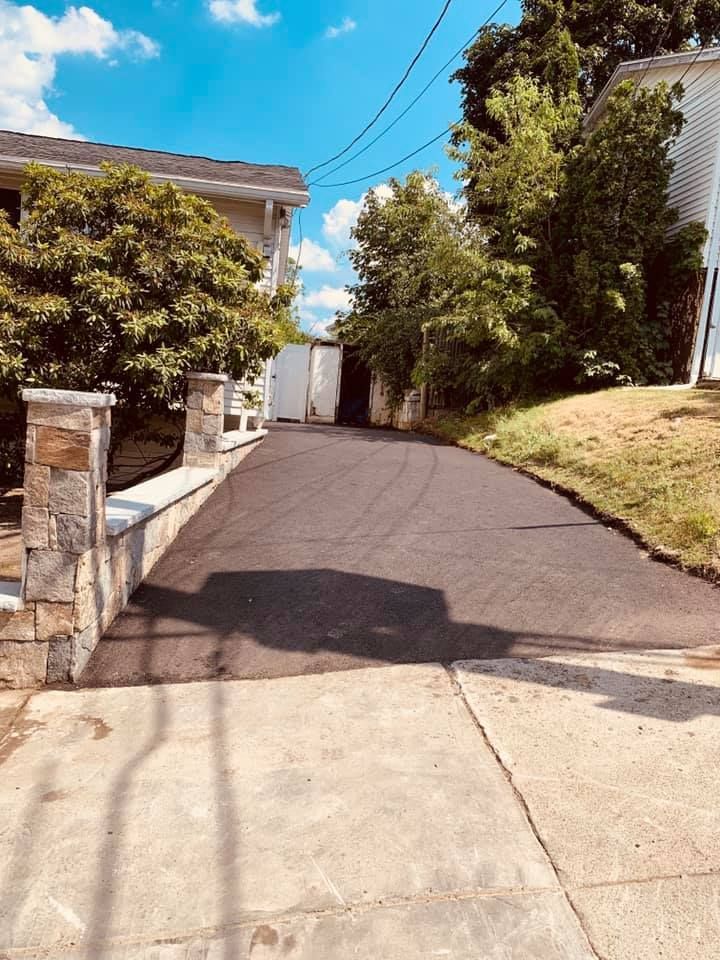 A driveway leading to a house on a sunny day.