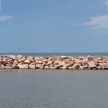 Rock breakwater with calm blue sea and sky