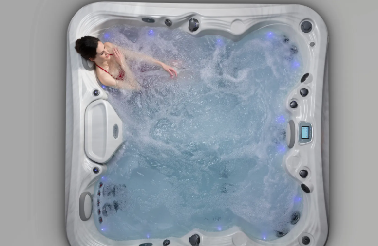 Woman relaxing in a hot tub with blue water and lights.