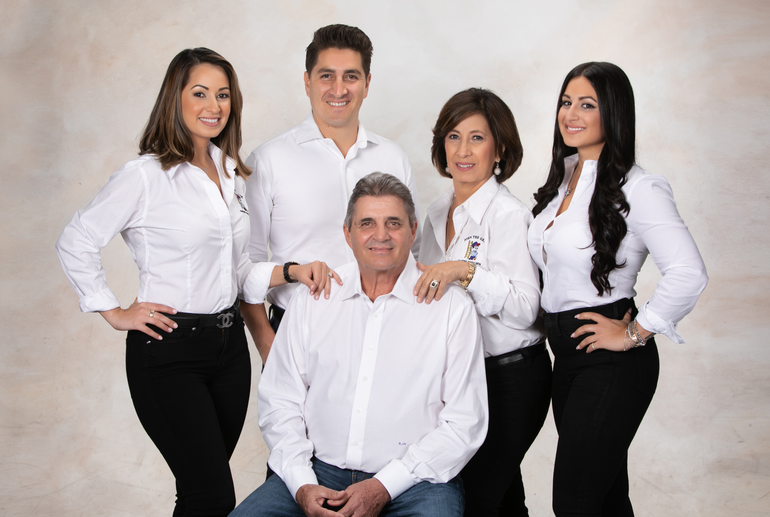 A group of people in white shirts are posing for a picture.