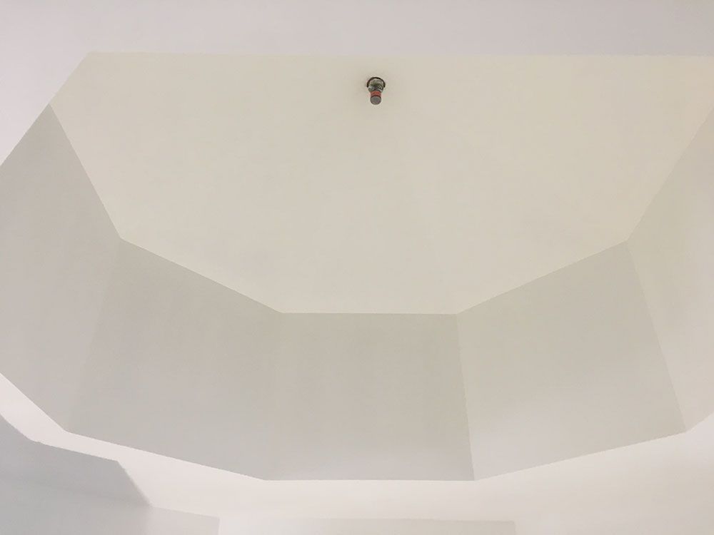 A white ceiling with a light hanging from it.