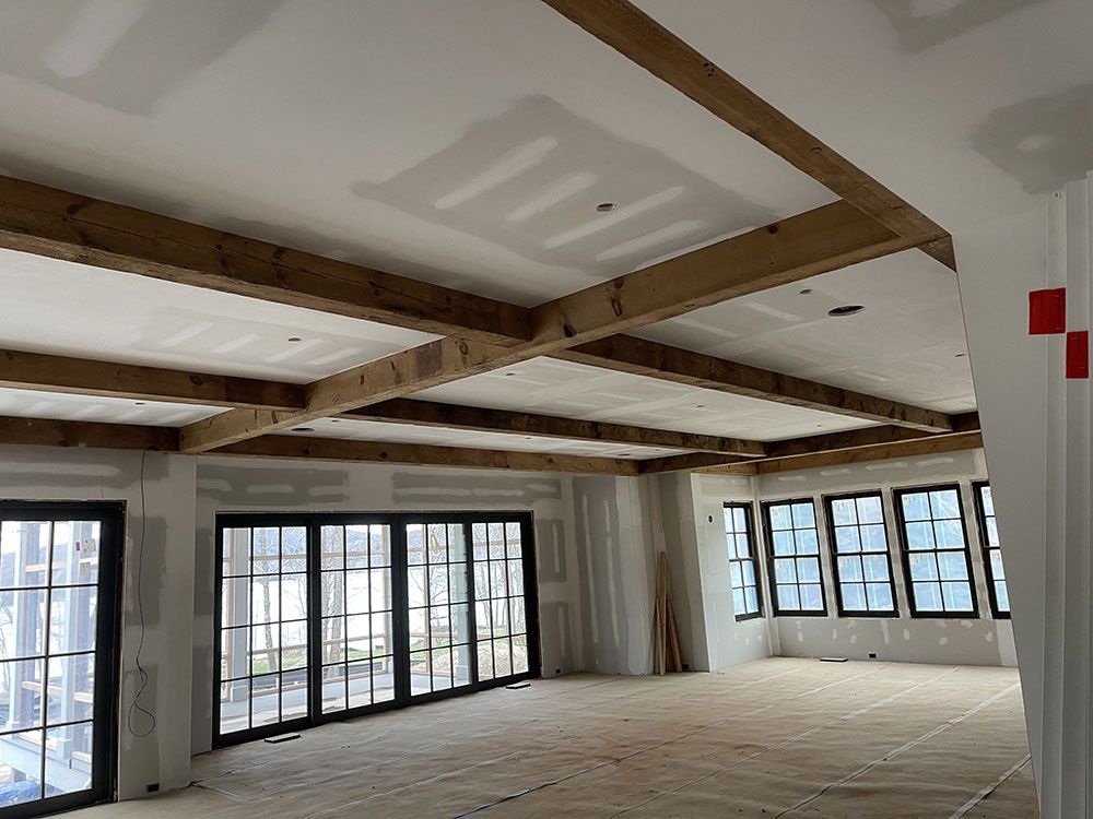 A large room with a lot of windows and wooden beams.