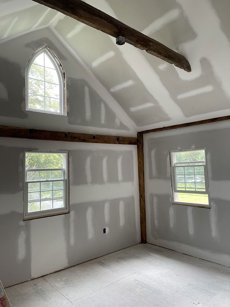 A room with a vaulted ceiling and a lot of windows.