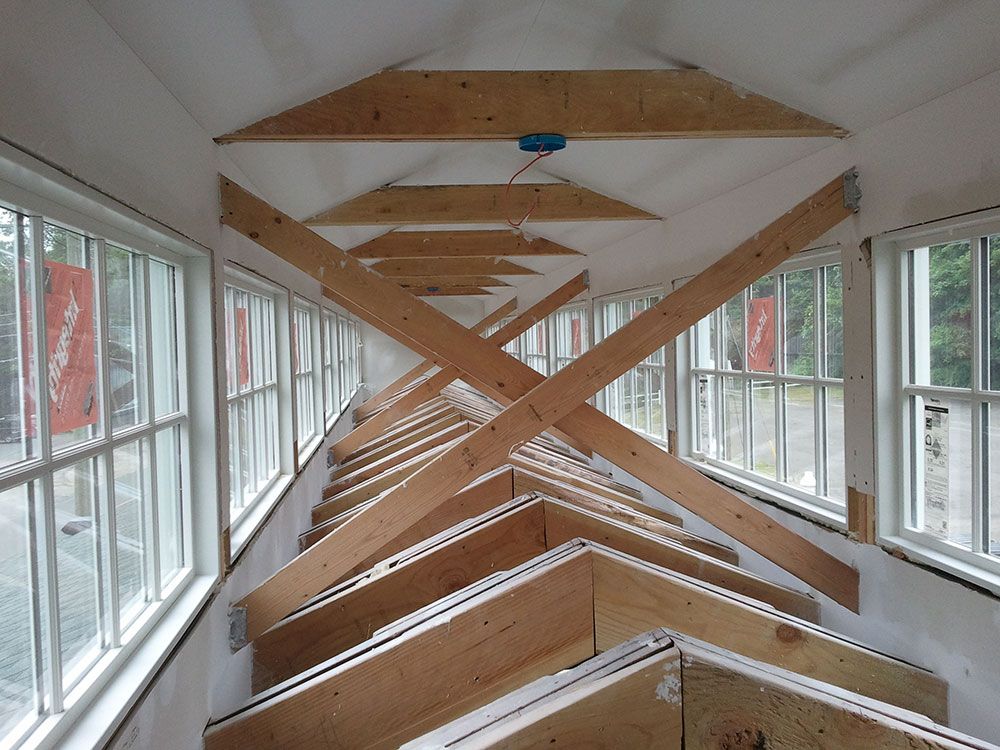 A building under construction with a lot of windows and wooden beams