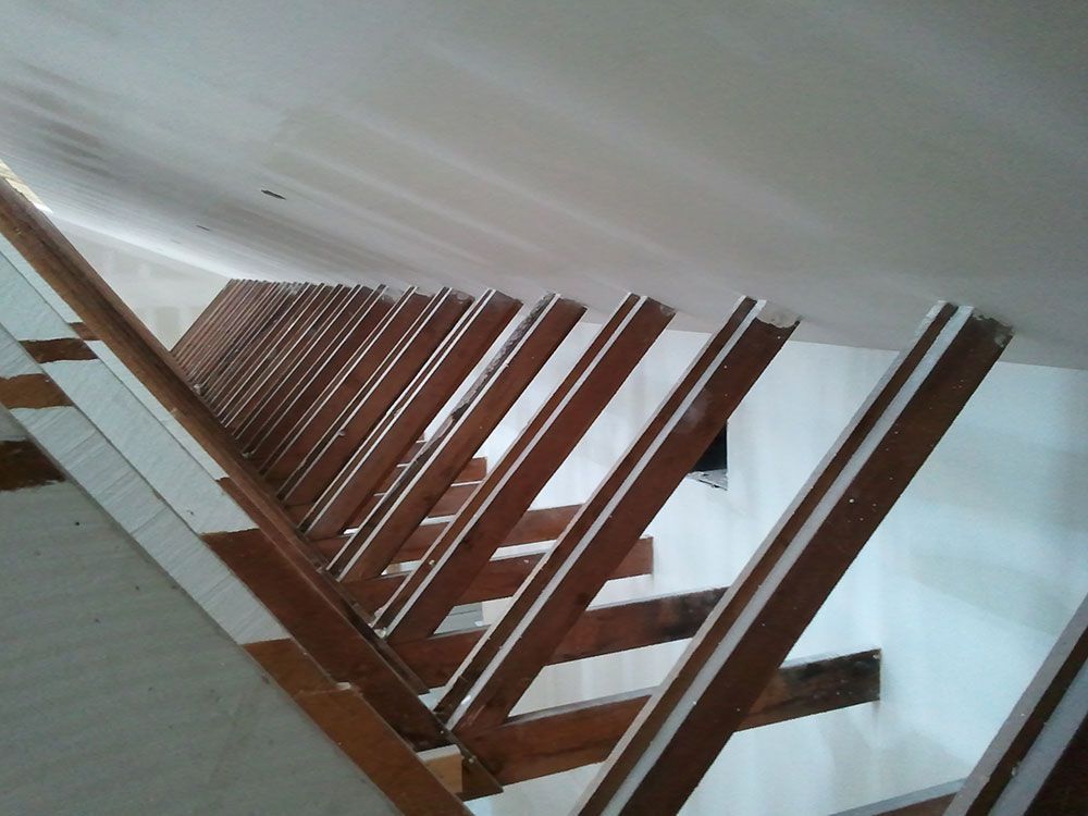 A set of wooden stairs with a white railing