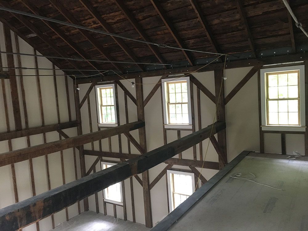 The inside of a building with wooden beams and windows