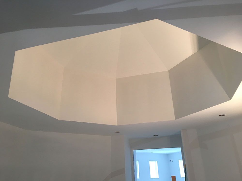 A white room with a ceiling that looks like a pyramid