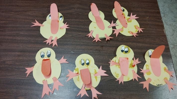 A bunch of paper ducks are sitting on a wooden table