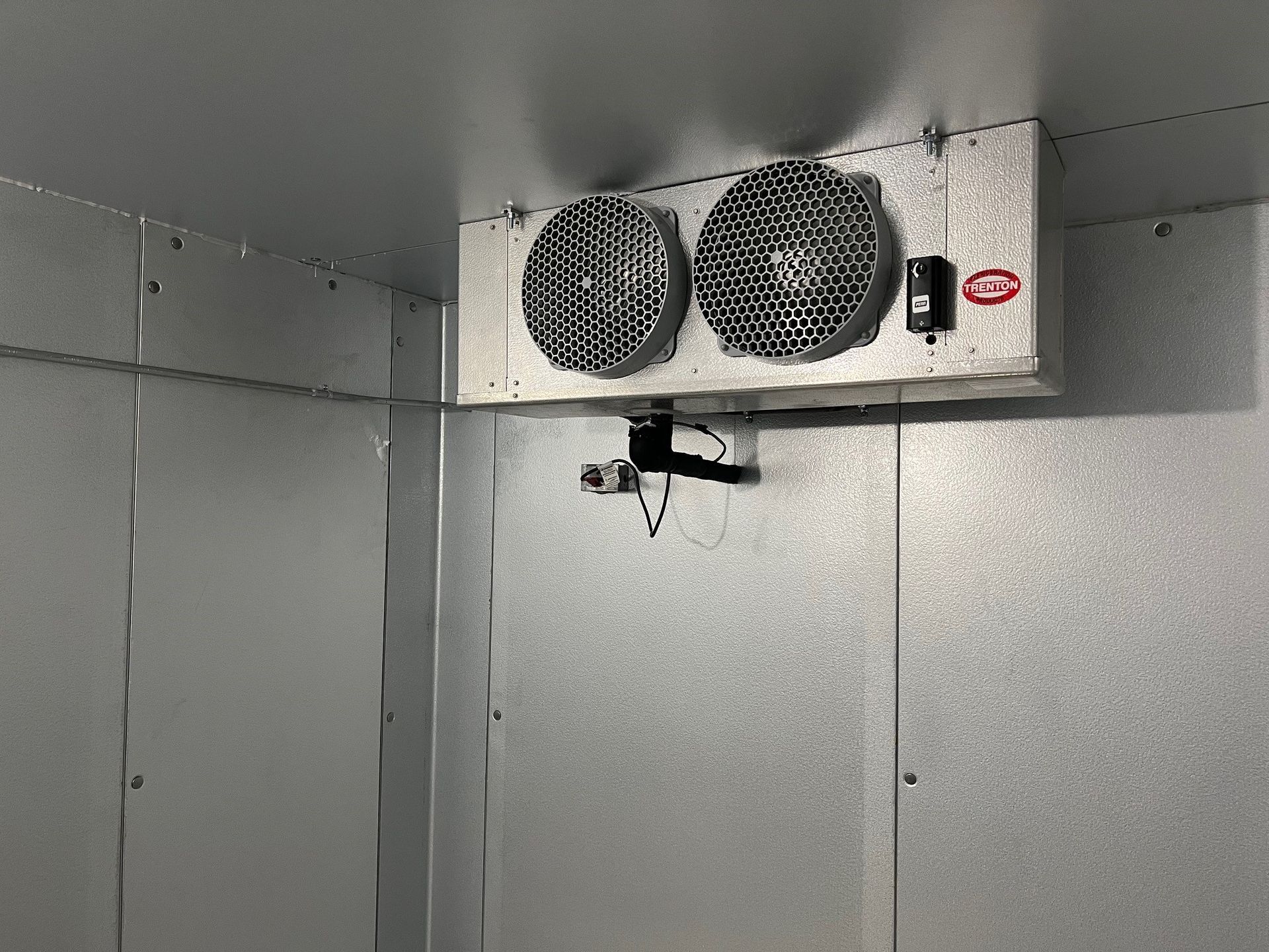 a room with two fans hanging from the ceiling .