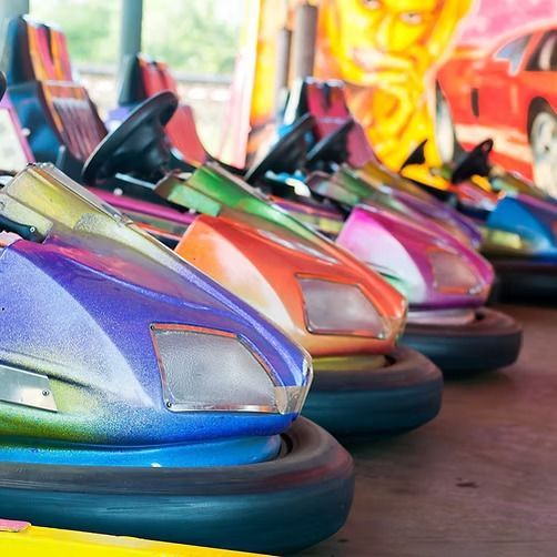 A bunch of colorful bumper cars are lined up in a row