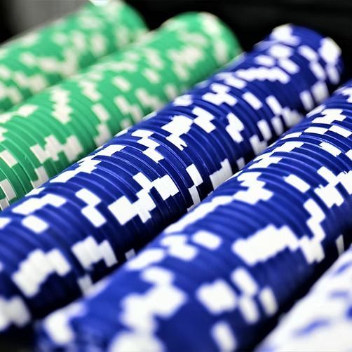 Blue and green poker chips are stacked on top of each other
