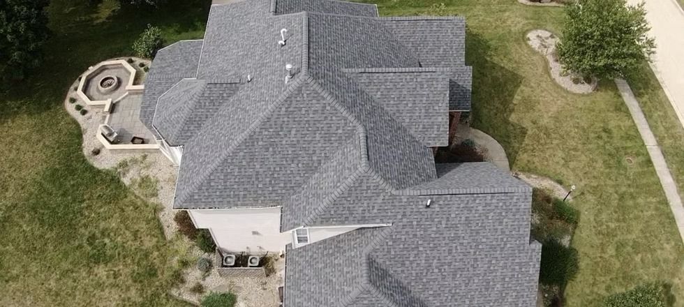 An aerial view of a large house with a gray roof.