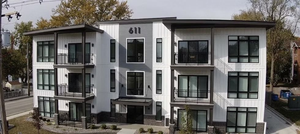 A large white apartment building with a lot of windows and balconies.