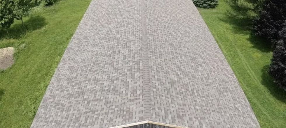 An aerial view of a gravel road surrounded by grass and trees.
