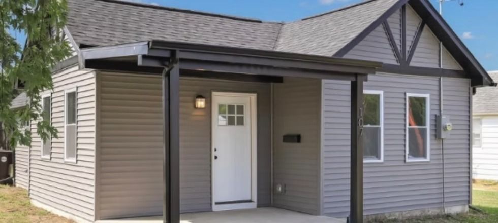 A small house with a porch and a white door.