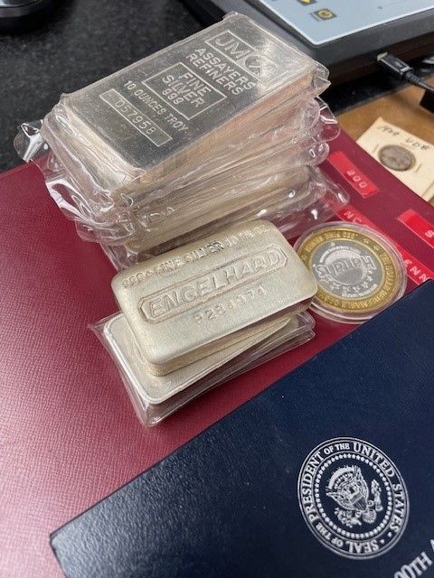 A stack of silver bars sitting on top of a red book