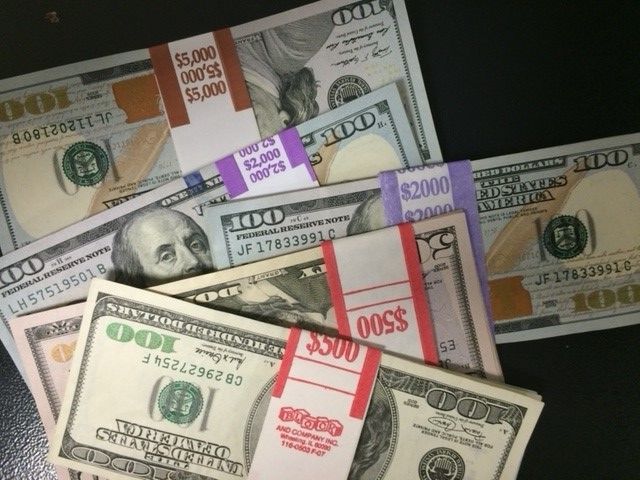 Several bundles of 100 dollar bills are stacked on top of each other