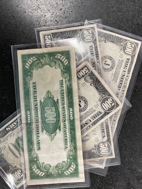 A bunch of 500 dollar bills are stacked on top of each other