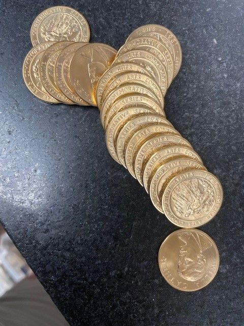 A bunch of gold coins are stacked on top of each other on a table.