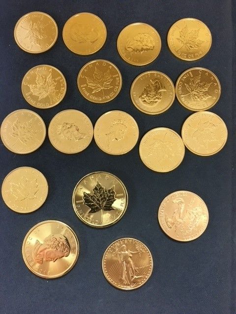 A collection of gold coins including one with a maple leaf on it