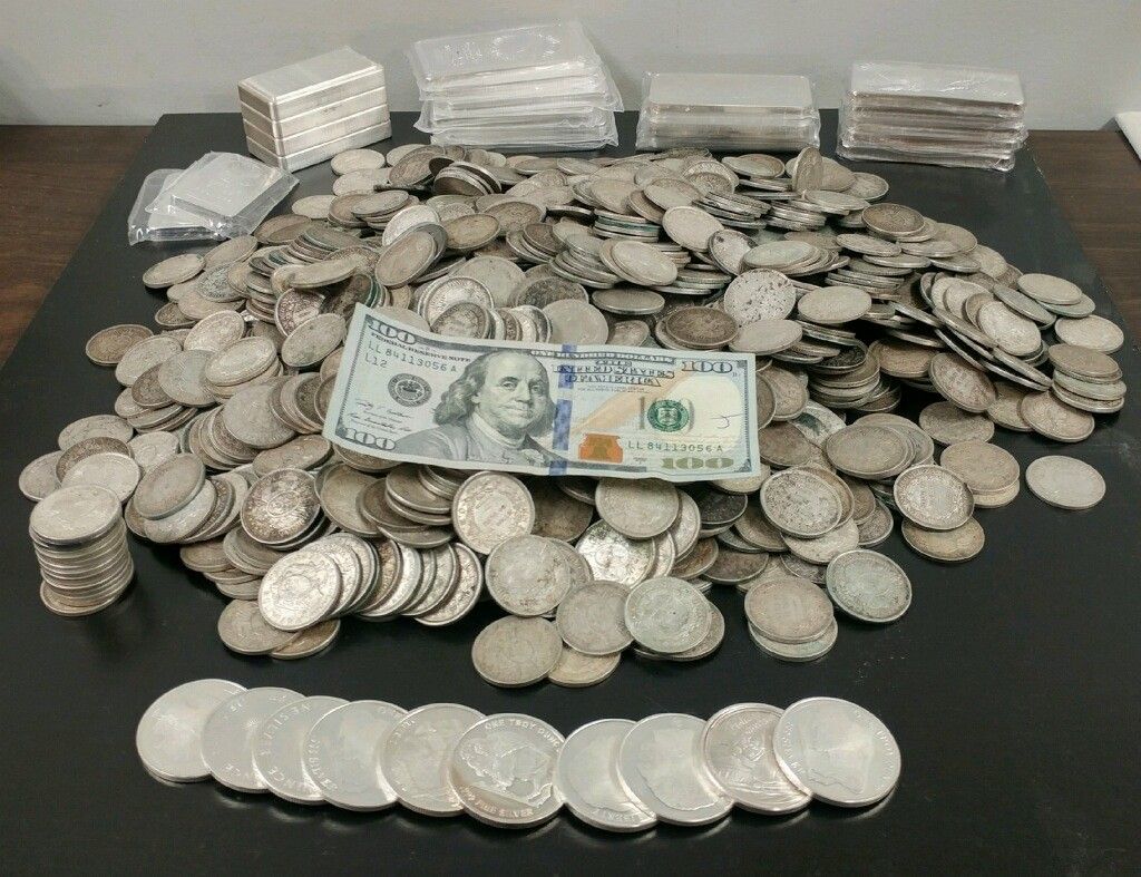A pile of coins and a dollar bill on a table
