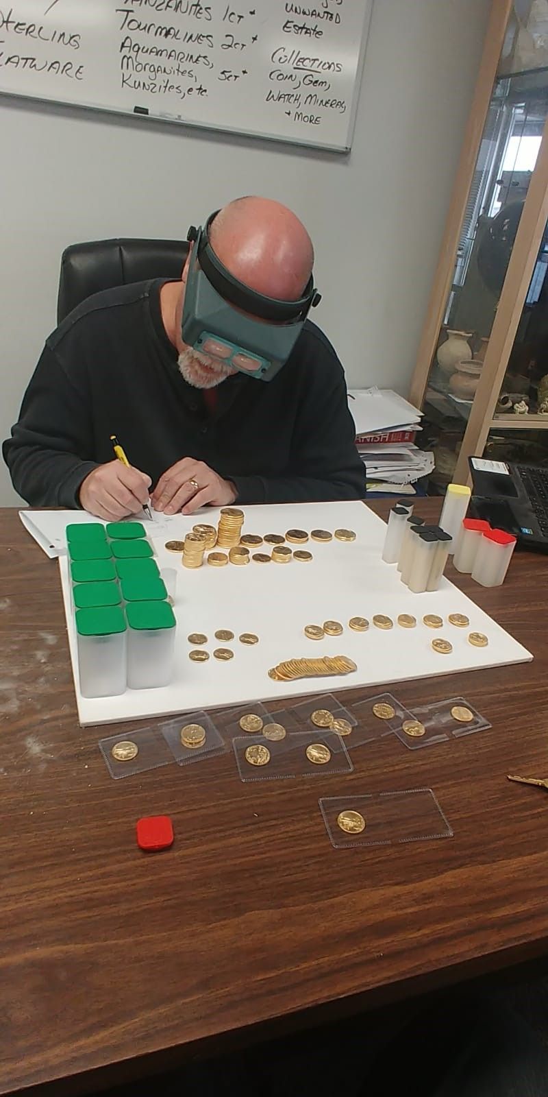 A man is sitting at a table with a magnifying glass on his head.