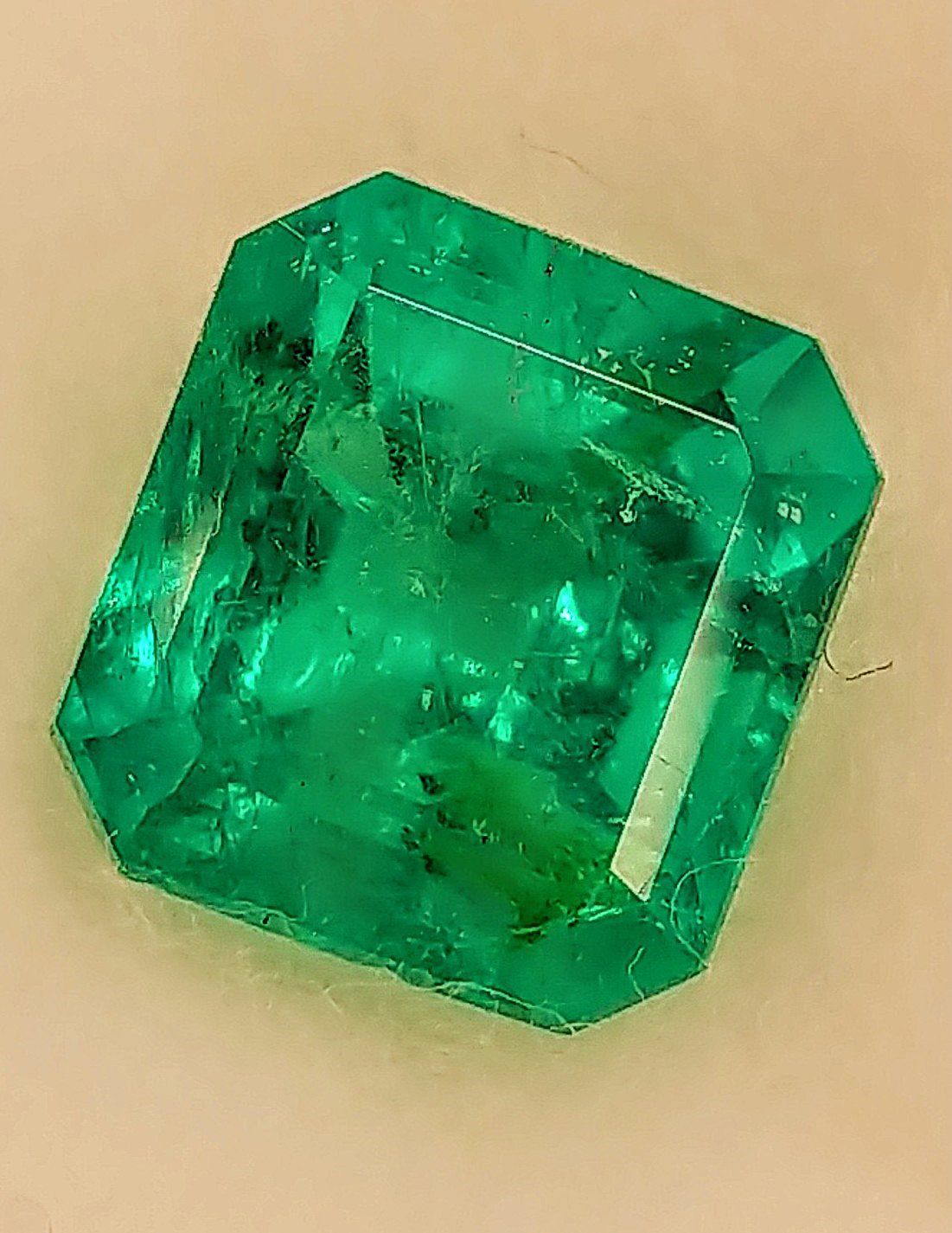 A square emerald is sitting on a table.