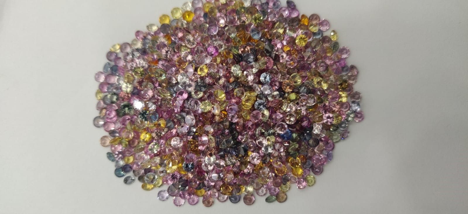 A pile of colorful beads on a white surface.