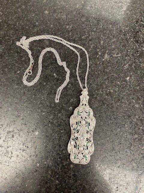 A necklace with a pendant is sitting on a counter.