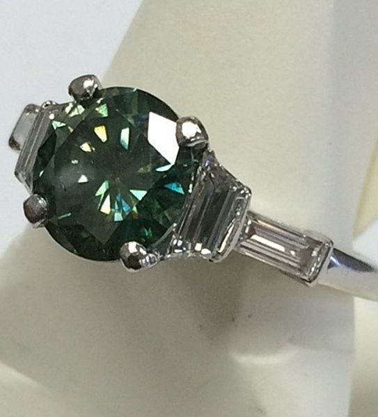 A ring with a green stone and baguette diamonds
