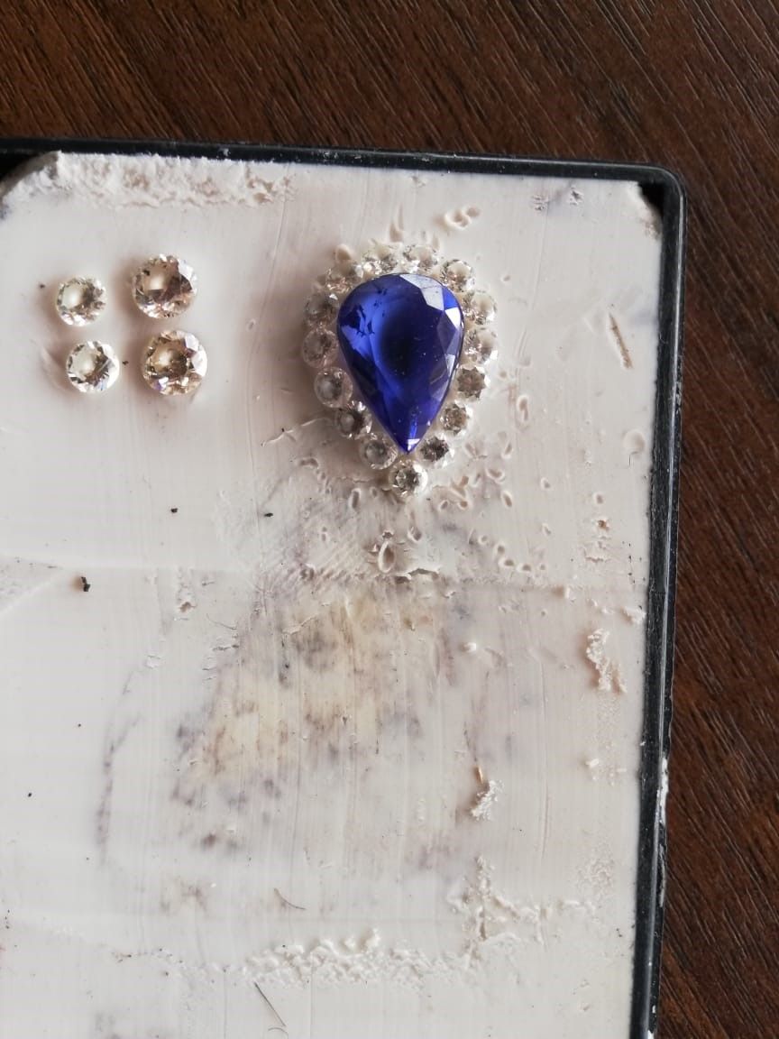 A pair of earrings with a blue stone in the middle