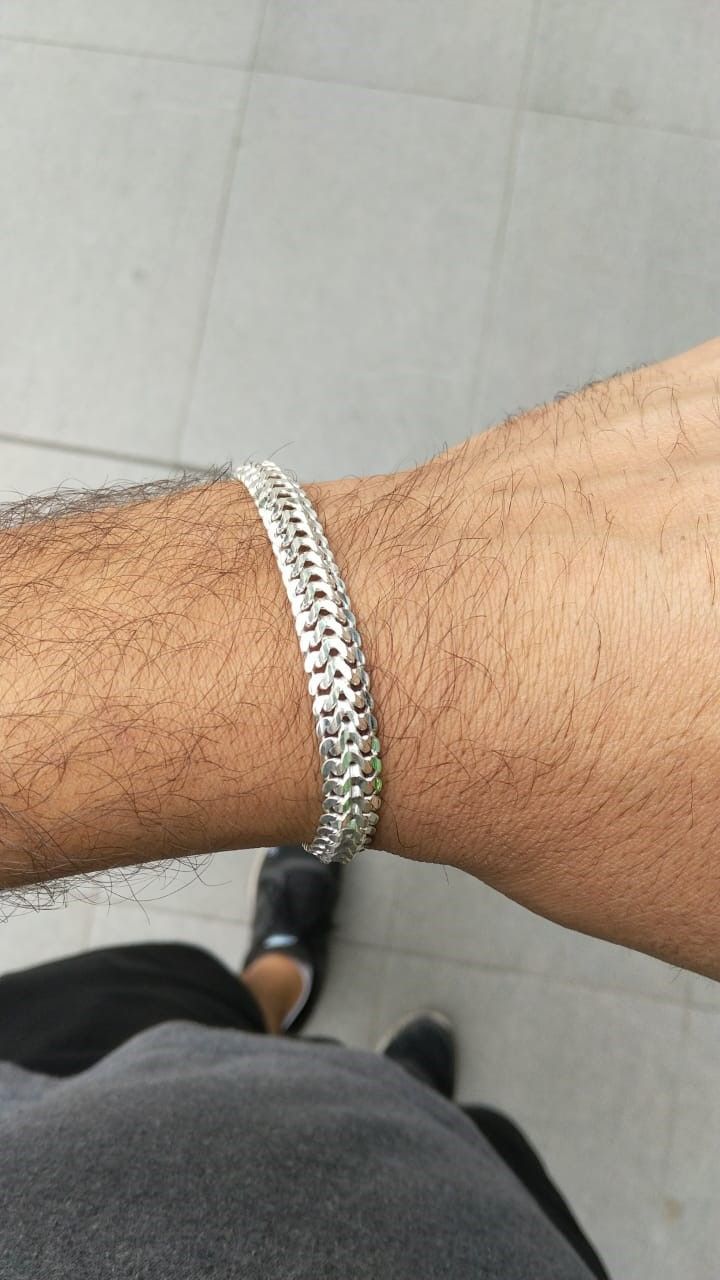 A man is wearing a silver bracelet on his wrist.
