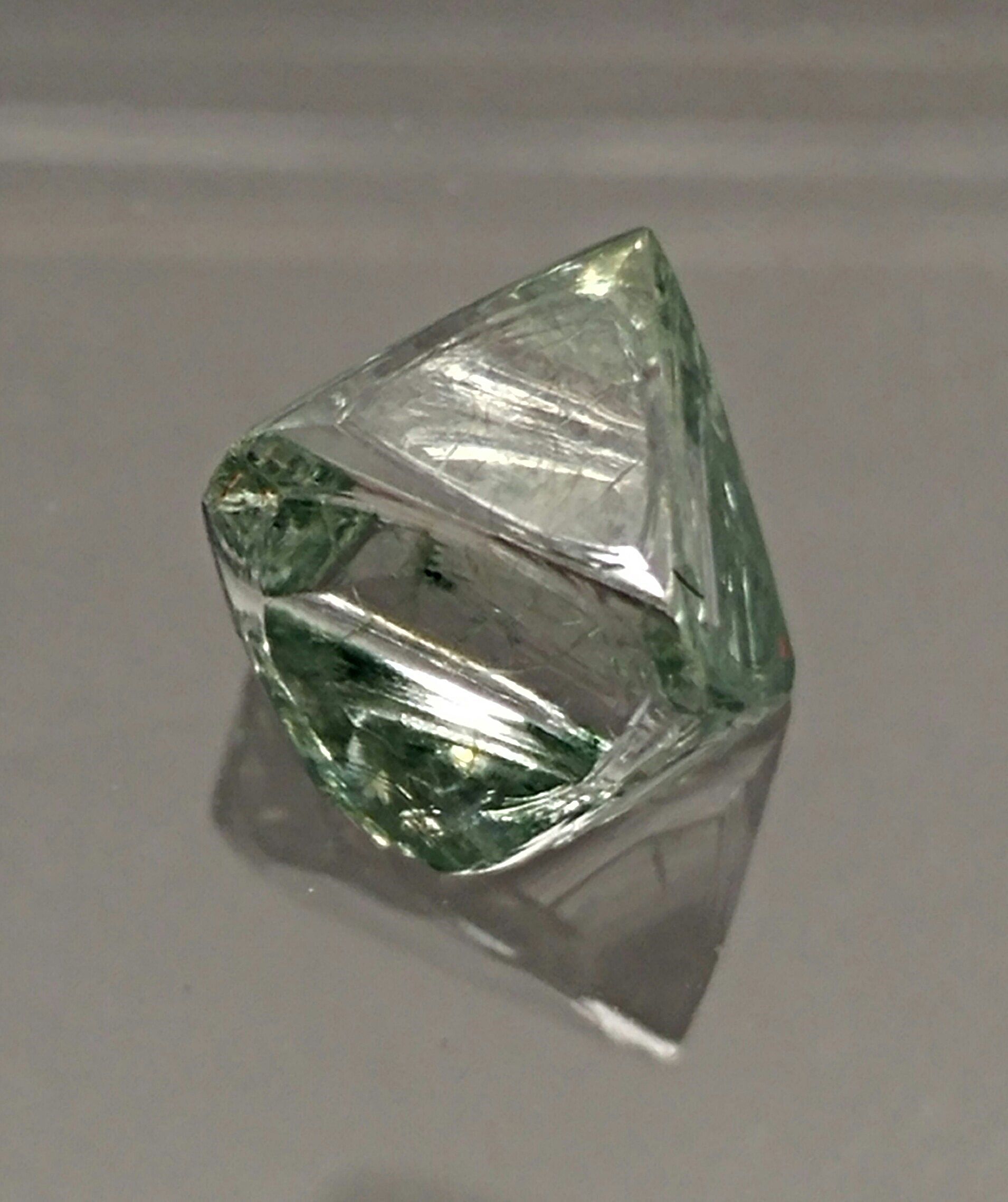 A close up of a green diamond on a table