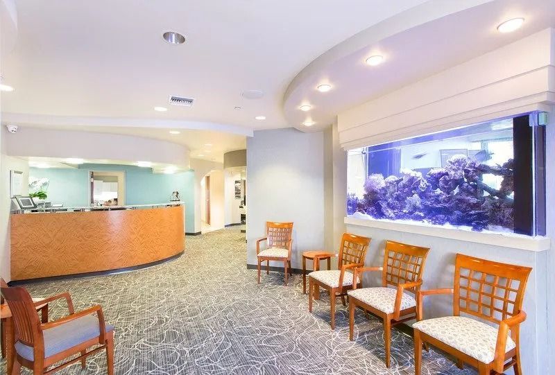 A waiting room with chairs and an aquarium on the wall